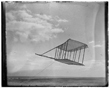 TITLE:  [Left side view of the 1900 Wright glider before installation of forward horizontal control surface, flying as a kite, tipped forward; Kitty Hawk Lifesaving Station and Weather Bureau buildings in background to the left]
CALL NUMBER:  LC-W85- 96 [P&P] REPRODUCTION NUMBER:  LC-DIG-ppprs-00556 (digital file from original) LC-W851-96 (b&w film copy neg.) CREATED/PUBLISHED:  [1900]
PART OF:  Glass negatives from the Papers of Wilbur and Orville Wright REPOSITORY:  Library of Congress Prints and Photographs Division Washington, D.C. 20540 USA